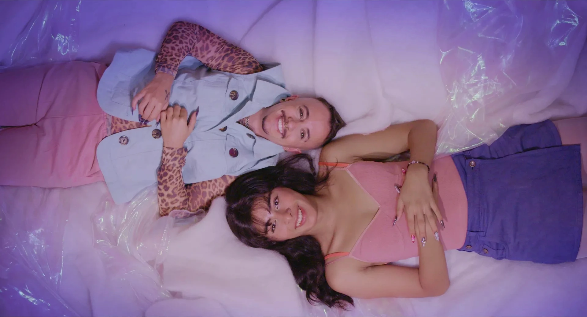 Karla and Lani are lying on a fluffy, pink surface.