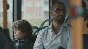 A tall and a small person sitting in public transportation